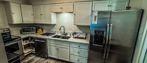 Réfrigérateur, un four, surface de cuisson, lave-vaisselle