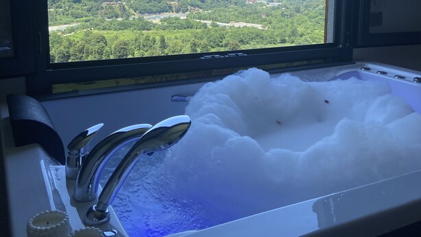 A bathroom with a window view of a mountainous landscape.