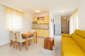 A compact living space with a dining area, a kitchen, and a living room.