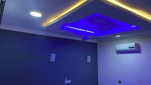 A room with a recessed ceiling, an air conditioning unit on the wall, and a ceiling fan. - Fully Furnished Studio Apartment (Tema)