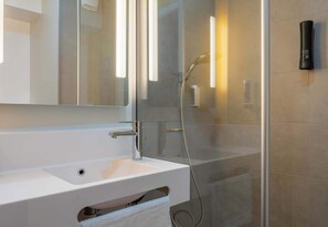 Een douche, handdoeken, zeep, toiletpapier