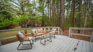 A wooden deck with wicker furniture and glass coffee table. - North Hills Oasis- 5mins from North Hills, Newly Renovated, Two En Suites!  (Raleigh)