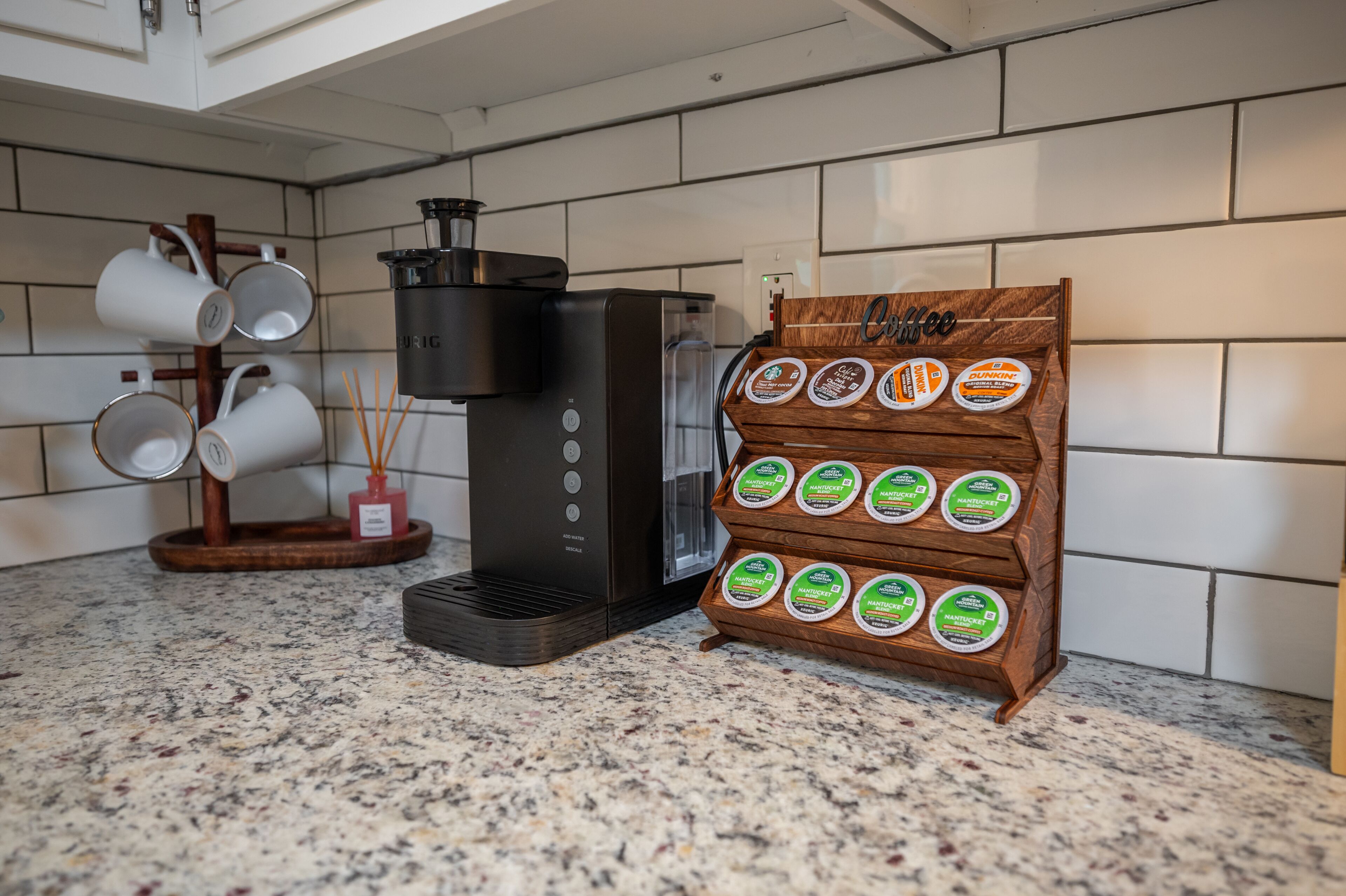 Une machine à café et une sélection de capsules de café disposées sur un plan de travail de cuisine.