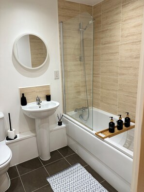 Sink, shower, and bathtub are conveniently located in this bathroom.