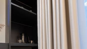 Una habitación con interior oscuro, una puerta de cristal y una cortina.