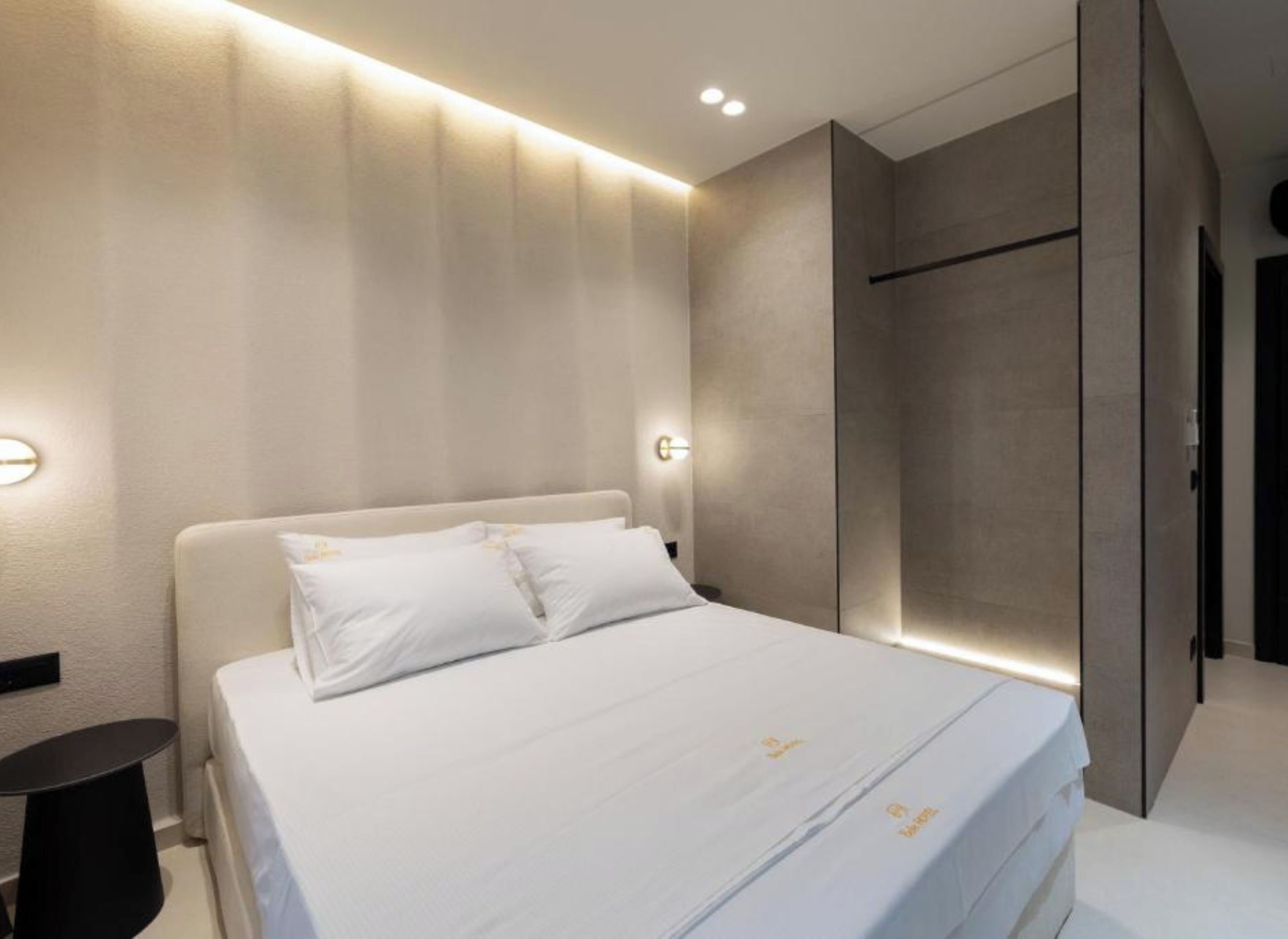 Ein modernes Schlafzimmer mit einem großen Bett, einem Nachttisch und einem Kleiderschrank.