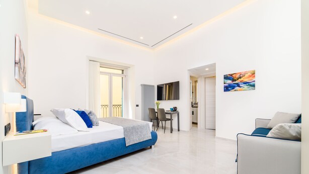Een moderne hotelkamer met een groot bed, een bureau en een zithoek.