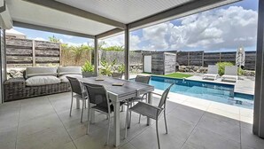 Un patio coperto con piscina, area relax all'aperto e vista sul cielo.