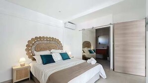 Una camera da letto moderna con un letto grande, un comodino con una lampada, una testiera in legno e uno specchio a parete.
