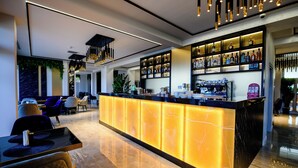 Un área de bar moderna con una encimera de mármol, asientos y una variedad de botellas de licores.