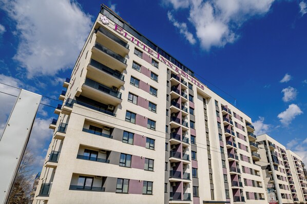Un hotel de varios pisos con balcones y un cielo despejado.