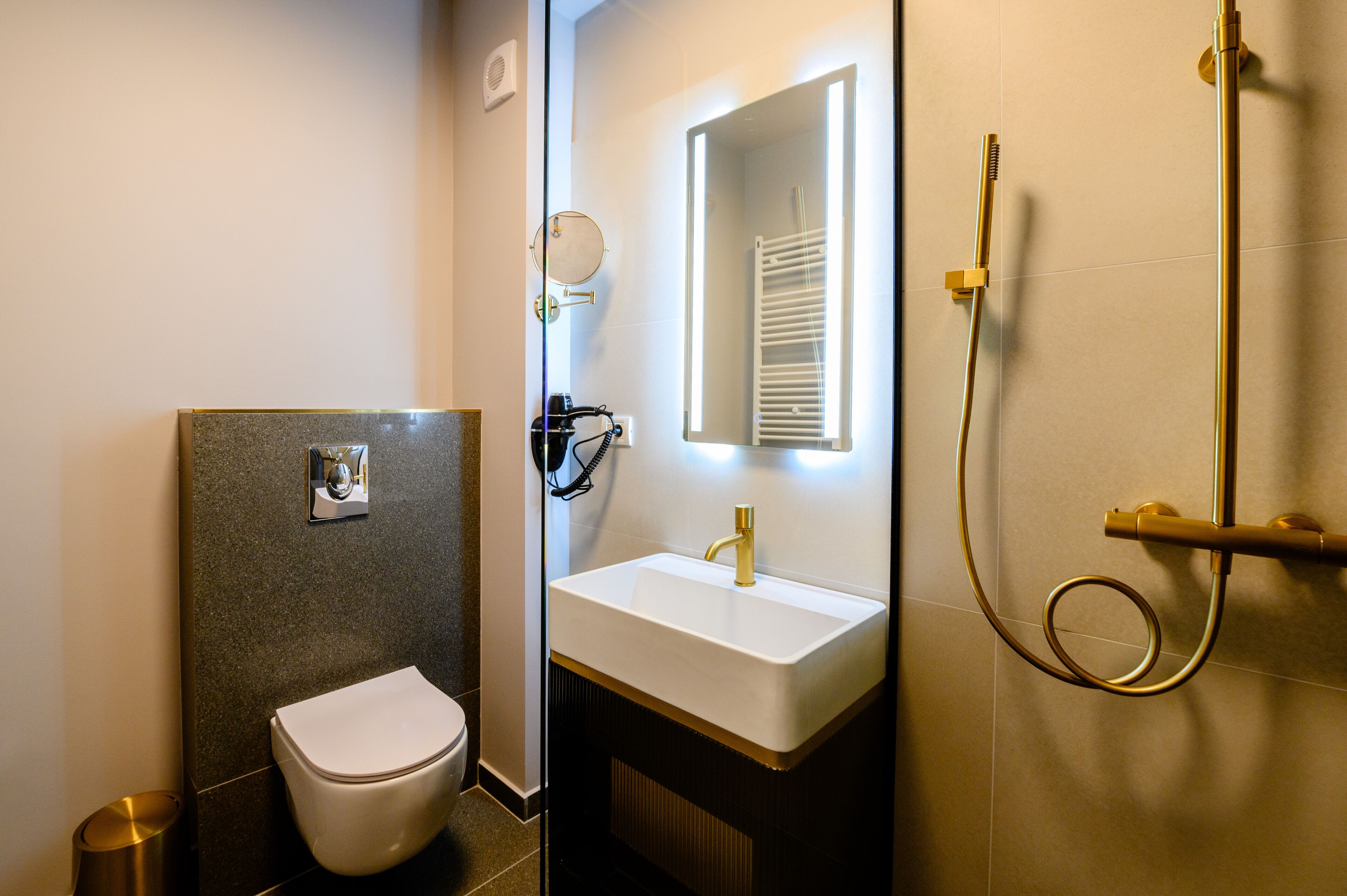 Ein modernes Badezimmer mit Toilette, Waschbecken und Dusche.