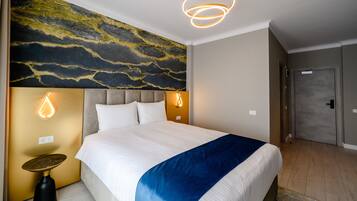 A hotel room with a large bed, a modern headboard, a wall with a textured mural, and a unique lighting fixture above the bed.