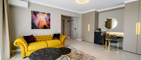 A modern living room with a yellow sofa, a black marble coffee table, and a contemporary light fixture.