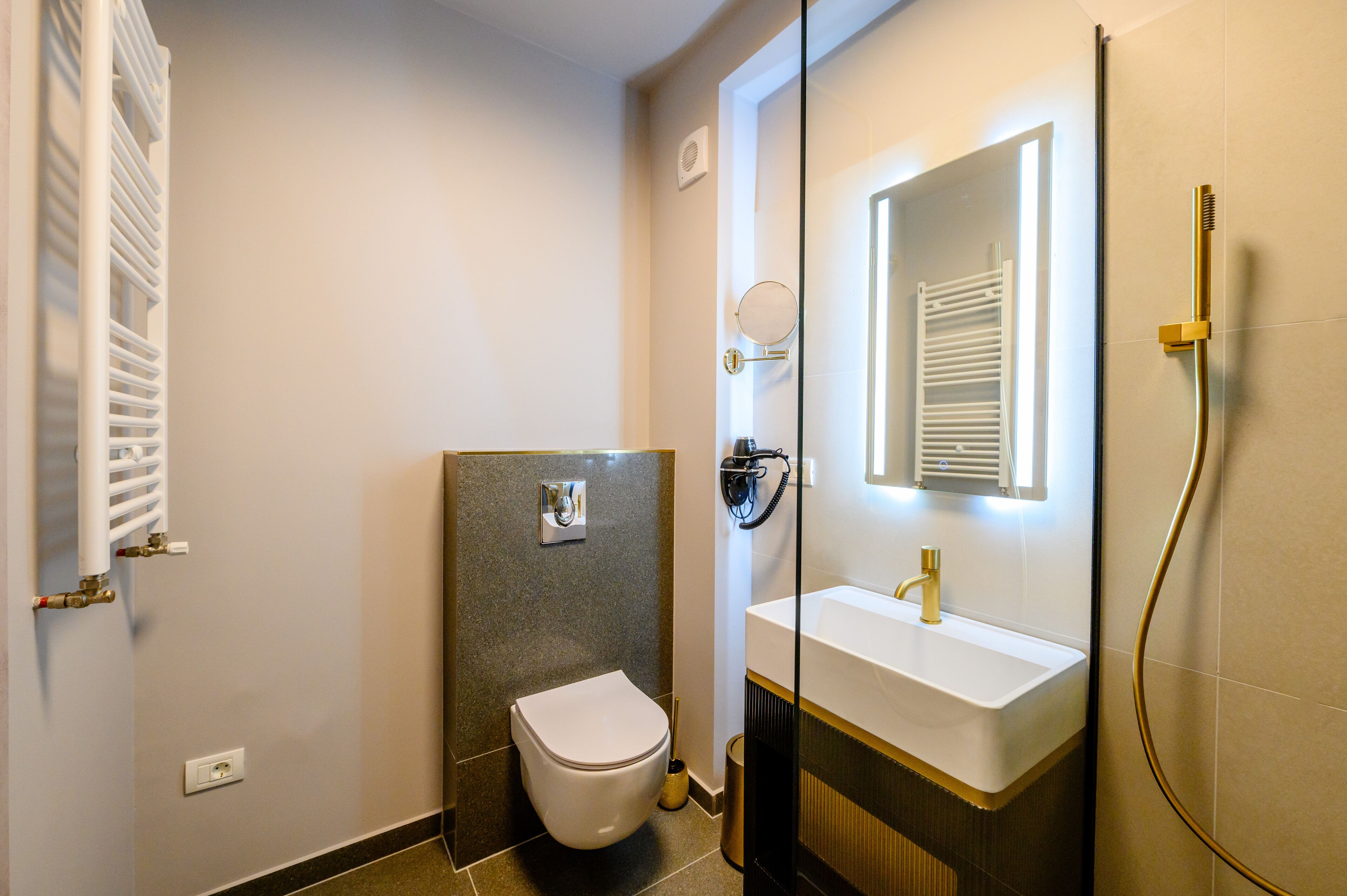 Une salle de bain moderne équipée de toilettes, d’un lavabo et d’une douche.