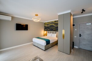 Un dormitorio moderno con una cama, un televisor y un armario.