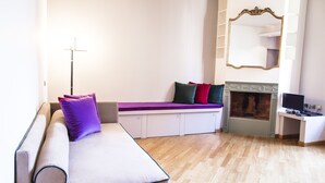A modern room with a sofa, a fireplace, a desk, and a mirror. - San Fermo Apartment (Milan)