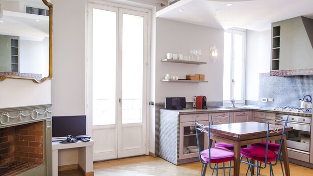 A modern kitchen with a dining area, a fireplace, and a large window. - San Fermo Apartment (Milan)
