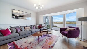 A modern living room with a grey sofa, a purple armchair, and a coffee table. - Fresh & Stylish | Ocean View | Donegal Town & Bay (Tullycullion)