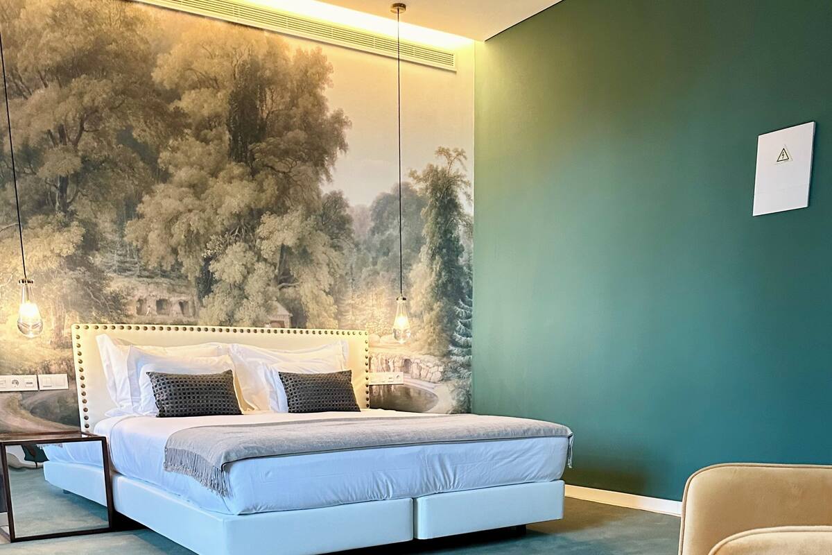 Un dormitorio con cama, mesita de noche y una silla.