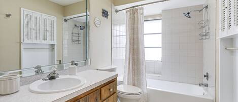 A bathroom with two sinks, a toilet, a bathtub, and a shower.