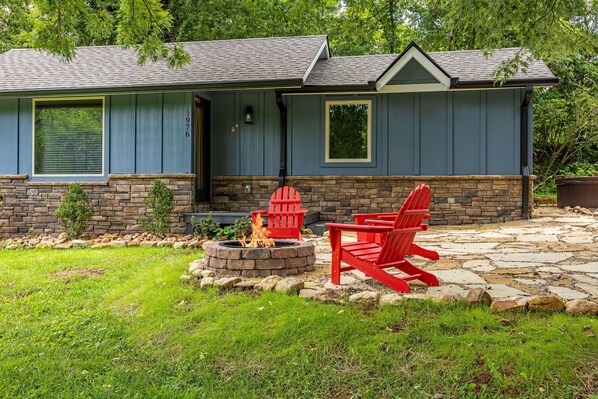 A house with a stone fire pit and red Adirondack chairs in the backyard. - I Do: Romantic Smokies Cabin! (GATLINBURG)