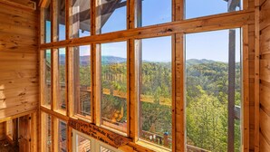 A cabin with large windows offering views of a forested mountain landscape. - The Joy Of The Mountain Tops (SEVIERVILLE)