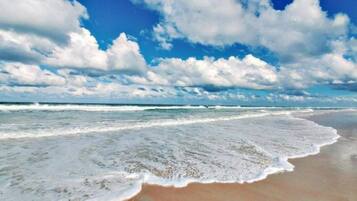 Rannalla, aurinkotuoleja, rantapyyhkeitä