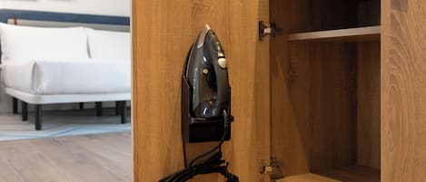 A wooden cabinet with a built-in ironing board and an iron.