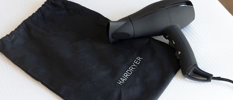 Un secador sobre un paño negro con la palabra 'HAIRDRYER' escrita en él.