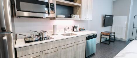 A modern kitchen with stainless steel appliances, a built-in microwave, and a dishwasher.