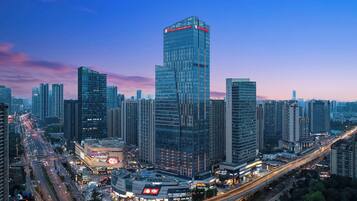 A high-rise hotel with a modern glass facade, surrounded by other tall buildings and busy streets.
