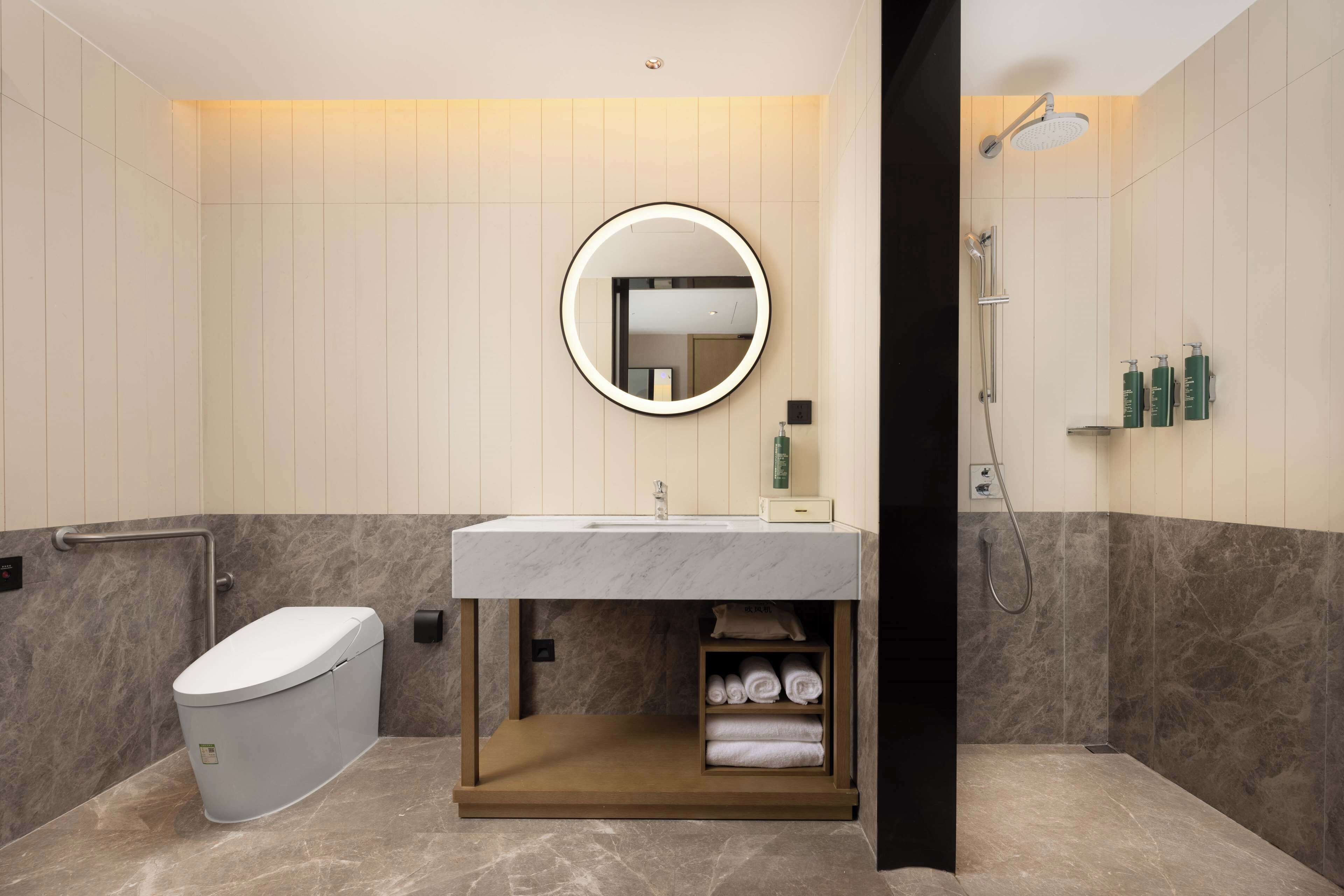 Ein modernes Badezimmer mit Toilette, Waschbecken und Dusche.
