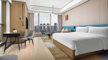 Une chambre d’hôtel moderne, dotée d’un grand lit, d’un bureau et d’une chaise.