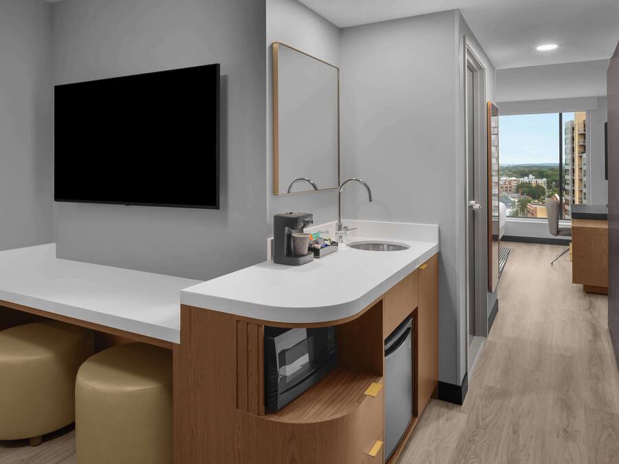 A modern kitchen with a white countertop, a built-in microwave, and a sink.
