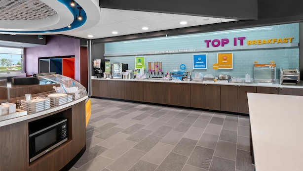 A breakfast area with a counter, microwave, and various food items. - Tru By Hilton Wauseon (Wauseon)