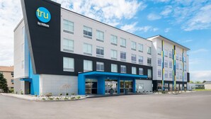 A modern hotel building with a prominent 'tru by Hilton' sign, multiple windows, and a covered entrance area. - Tru By Hilton Wauseon (Wauseon)