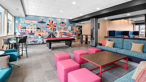 A modern lounge area with a pool table, seating, and a mural depicting Dover Township, Ohio. - Tru By Hilton Wauseon (Wauseon)
