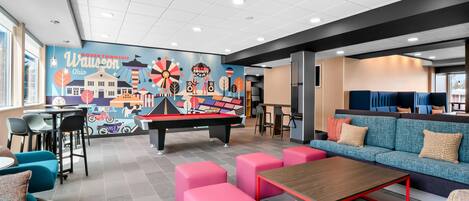 A modern lounge area with a pool table, seating, and a mural depicting Dover Township, Ohio.