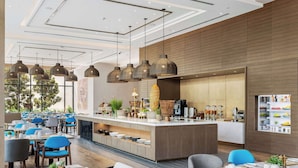 Un restaurante moderno con una isla central, sillas azules y lámparas colgantes.