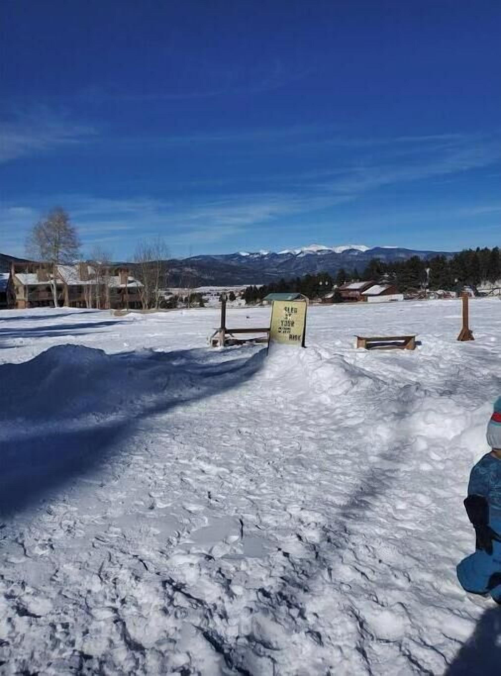 Schneelage mit einem Schild, das einen Skiliftbereich kennzeichnet.