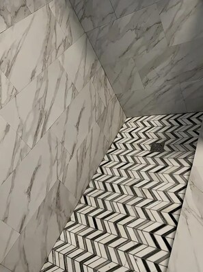 Un coin de pièce dotée d’un sol en marbre et d’un motif de carrelage en chevron noir et blanc.