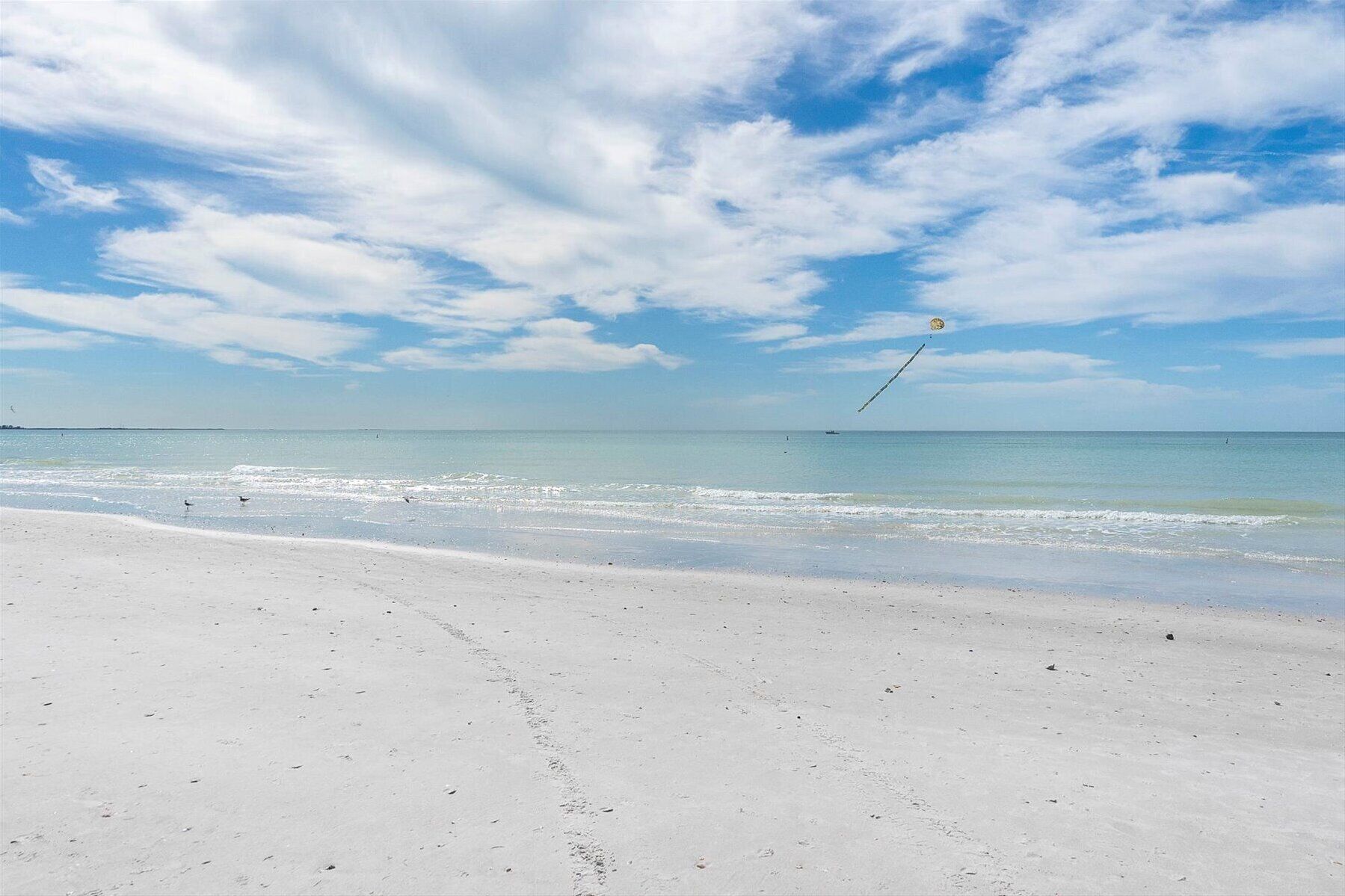 Ein Strand mit weißem Sand und blauem Himmel.