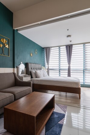 Une chambre à coucher moderne avec un lit, un canapé, une table de chevet et une table basse.