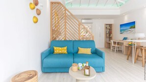 Una sala de estar moderna con un sofá azul, detalles de madera y un tragaluz.