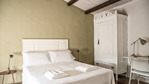 A bedroom with a bed, a wardrobe, a desk, and a chair. - Casa Talia Houses (Modica)