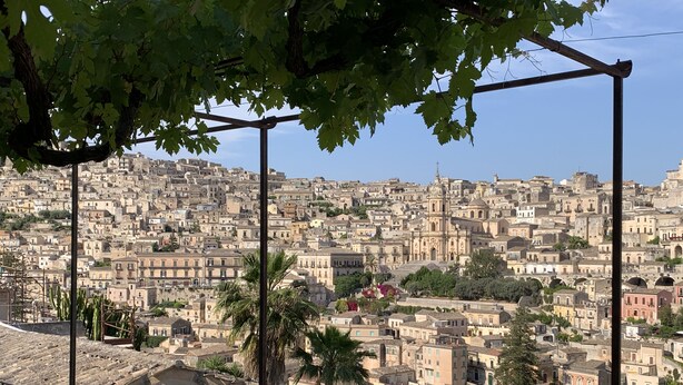A terrace with a view of a densely packed cityscape, including historic buildings and a prominent church. - Casa Talia Houses (Modica)
