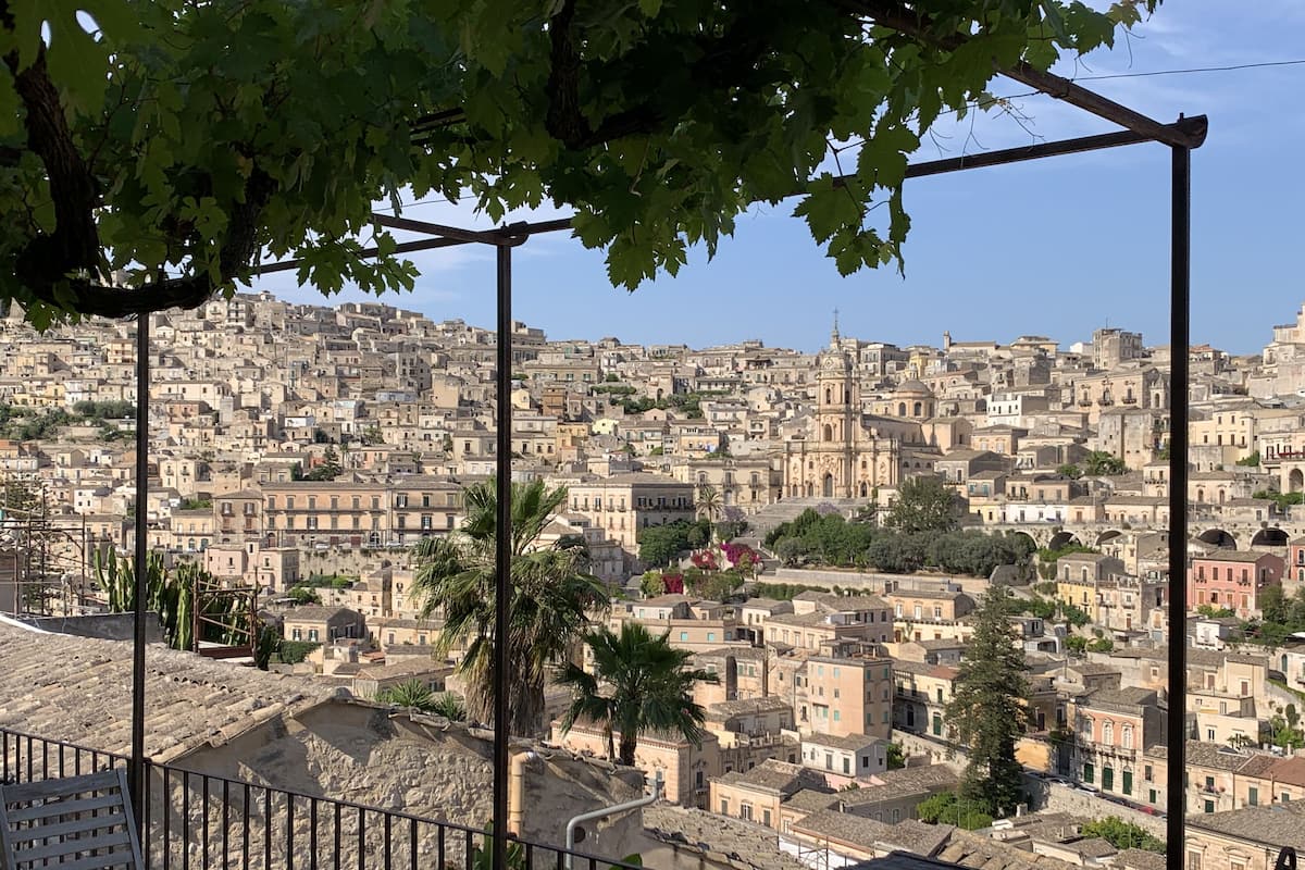 A terrace with a view of a densely packed cityscape, including historic buildings and a prominent church.