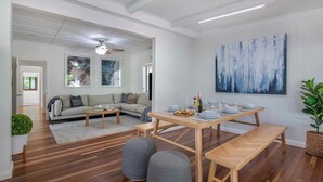 A spacious living area with a dining table set for four, a sofa, and a ceiling fan. - Sunset Haven 4-Bd Retreat Milton, Steps to Stadium (Petrie Terrace)
