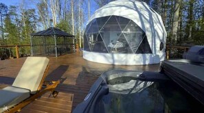 A geodesic dome structure with a transparent roof, a hot tub, and a deck with lounge chairs. - Contrast Cove Dome in Smoky Mountains - GlampiTiN

 (Hartford)